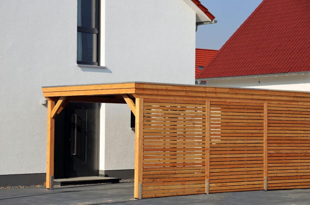 Timber-slat carport with privacy screening attached to a modern home entrance